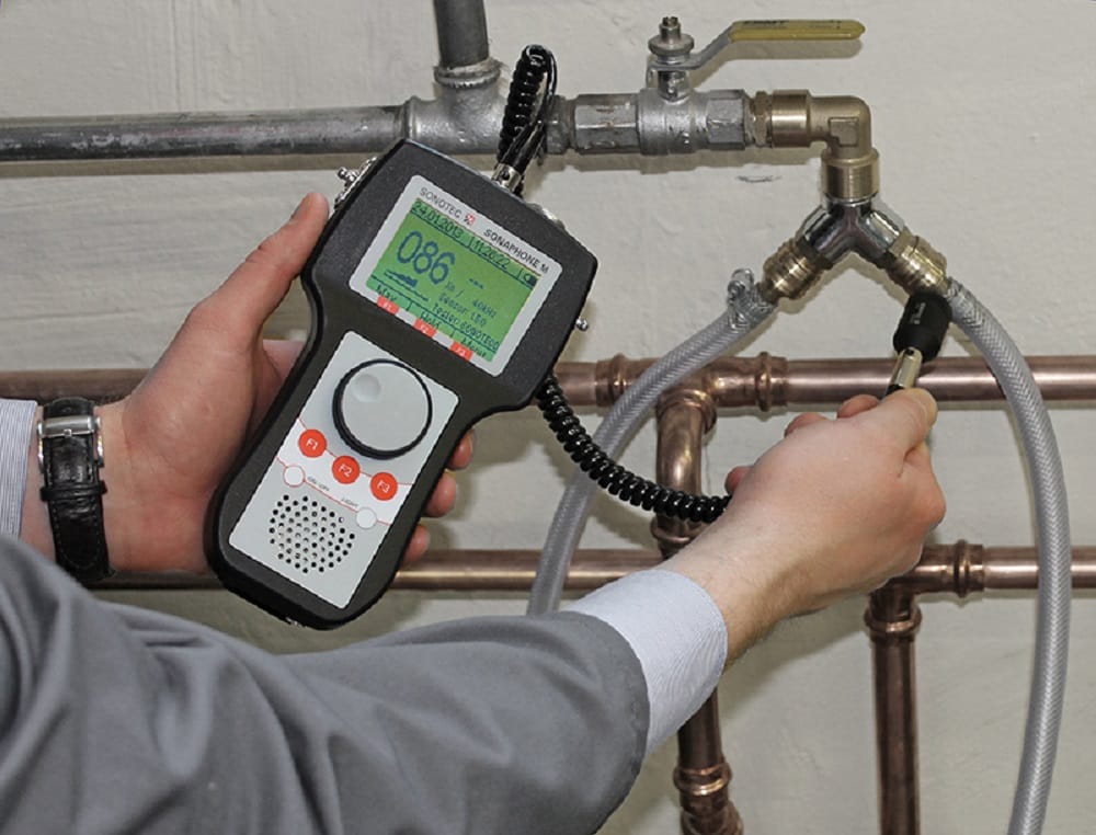 Plumber testing pipes with electronic leak detection equipment in Redmond