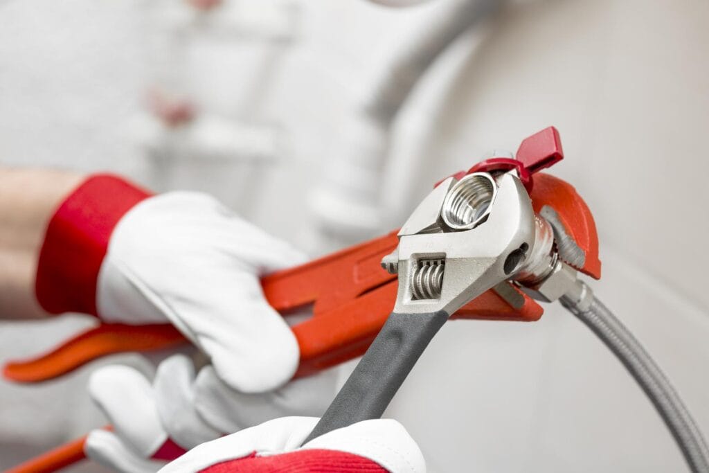 Plumber holding pipe wrenches for an emergency repair in Redmond