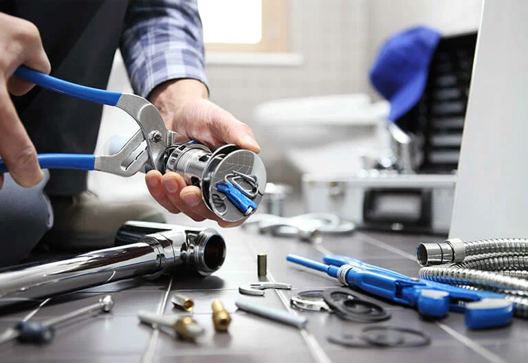 Technician repairing a plumbing fixture with professional tools in Redmond