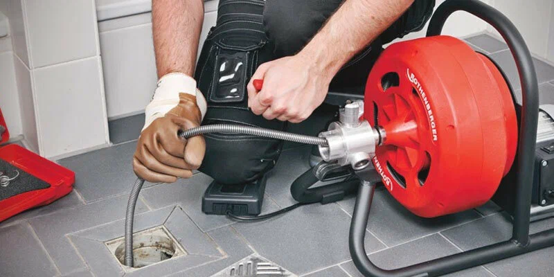 Plumber using a drain-cleaning machine in Redmond