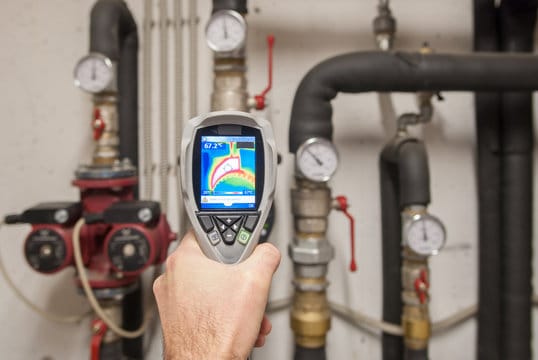 Plumber using a thermal imaging camera to inspect pipes in Redmond