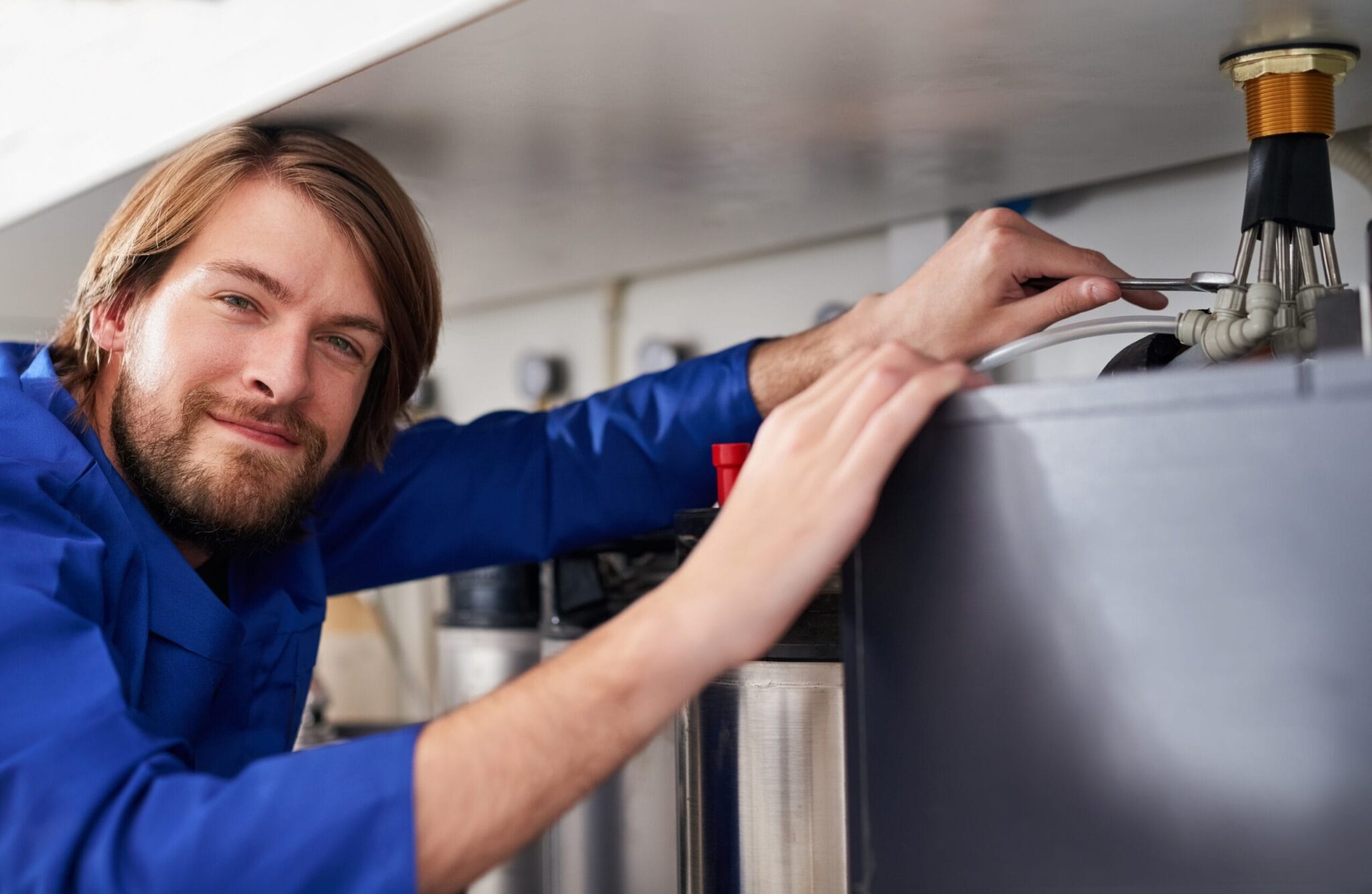 Technician servicing a residential water heater tank in Redmond